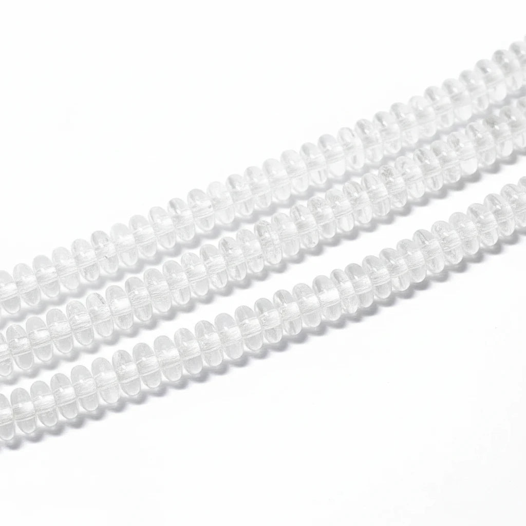 Clear glass or acrylic oval beads strung in multiple rows on a white background.