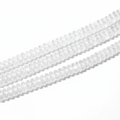 Clear glass or acrylic oval beads strung in multiple rows on a white background.