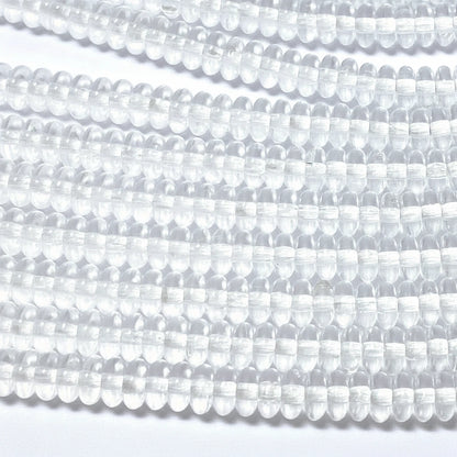 Clear round faceted beads strung in multiple rows on a white background.