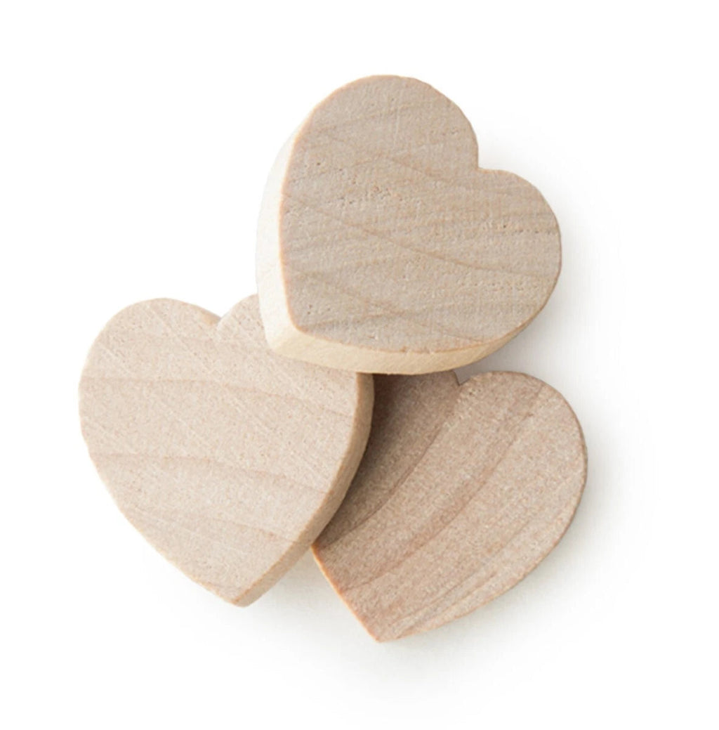 Three unfinished light wood heart-shaped blocks with visible grain, arranged on a plain white background.