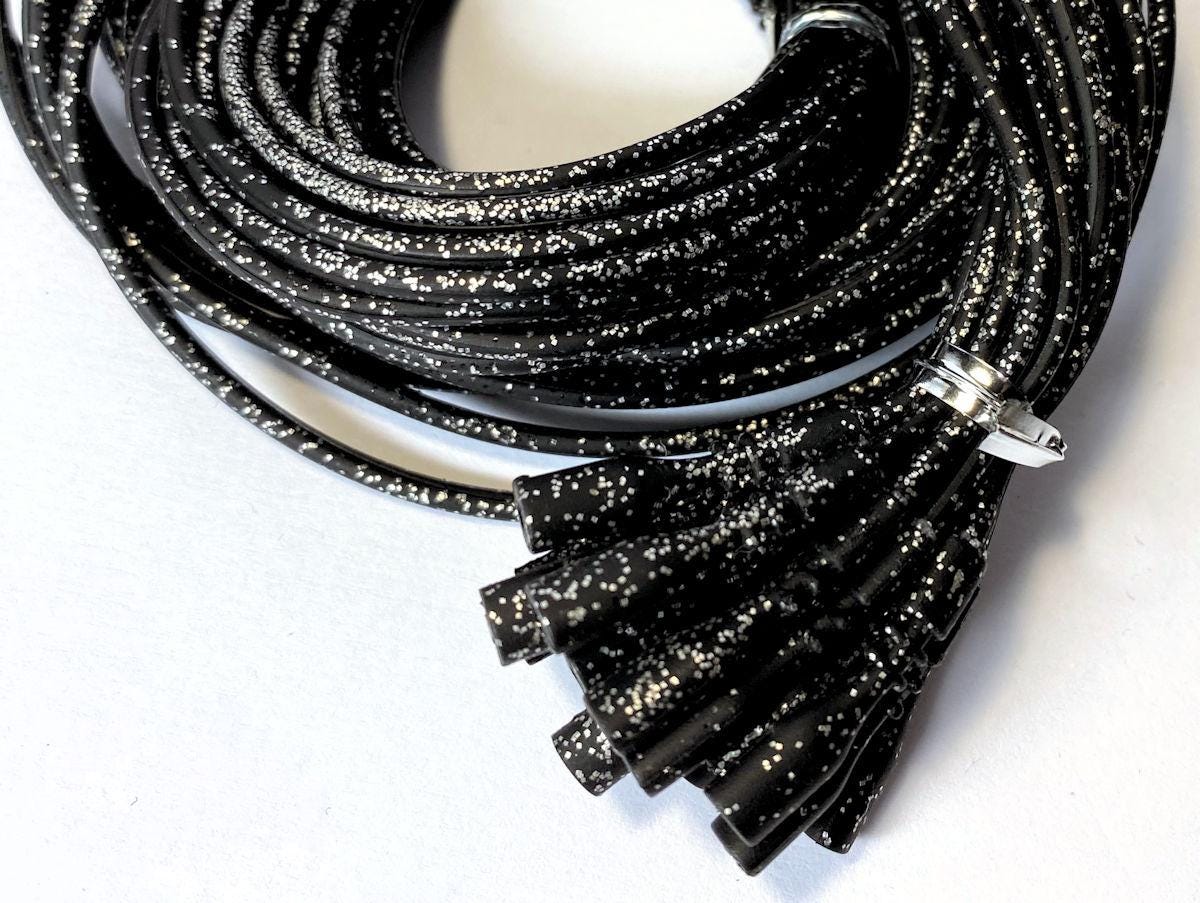 Black glittery cords with connectors on a white background