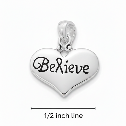 A silver heart-shaped pendant charm engraved with the word 'Believe' in black script, shown on a white background with a dimension line indicating 1/2 inch line.