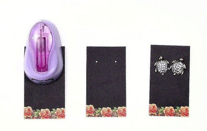 Purple hair tie and turtle-shaped earrings on black cards with floral designs.
