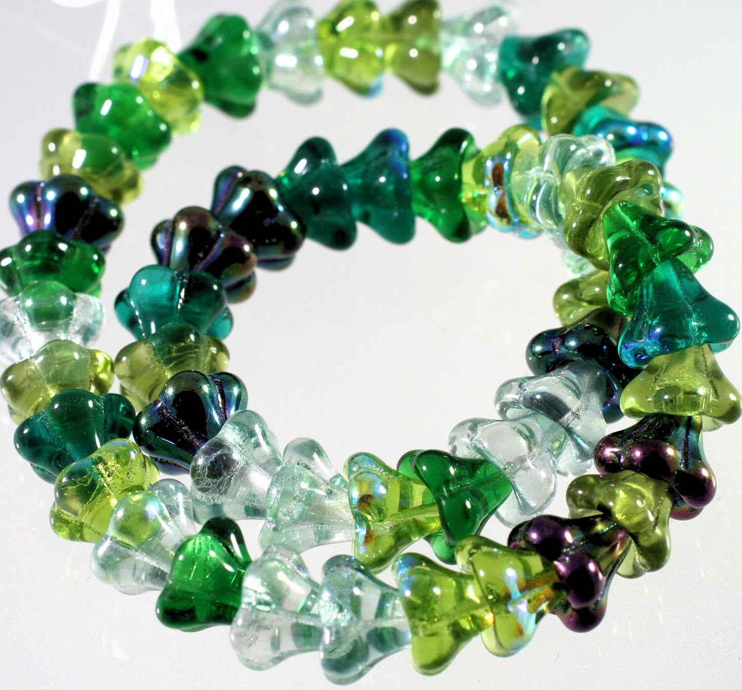 green and purple beaded design on a white background