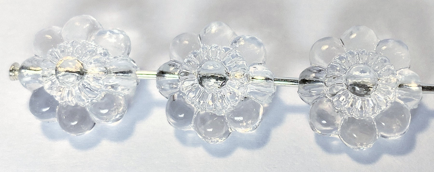 Clear floral beads
 on a reflective surface
