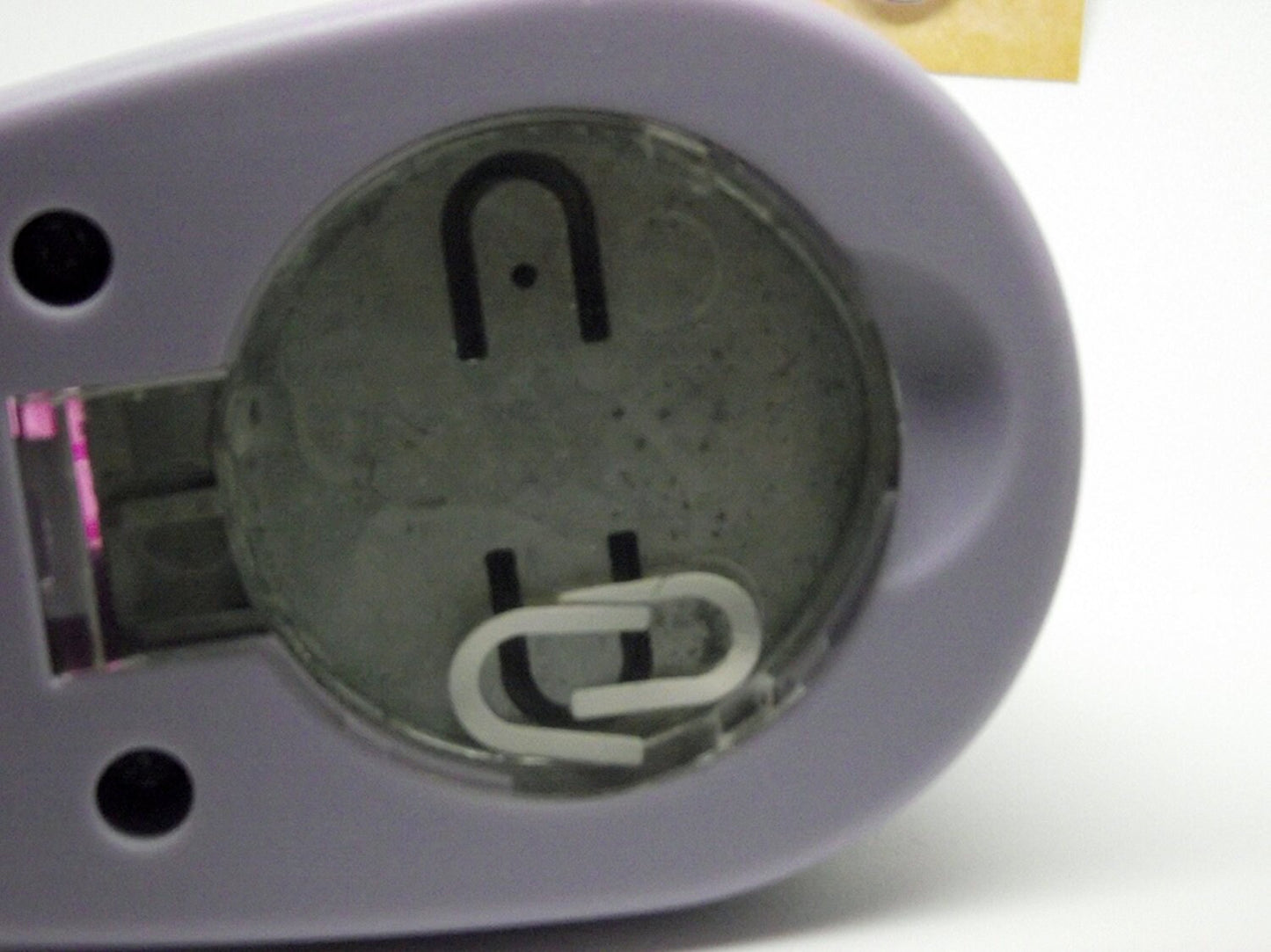 Close-up of a small  device with a clear cover, showing internal components.