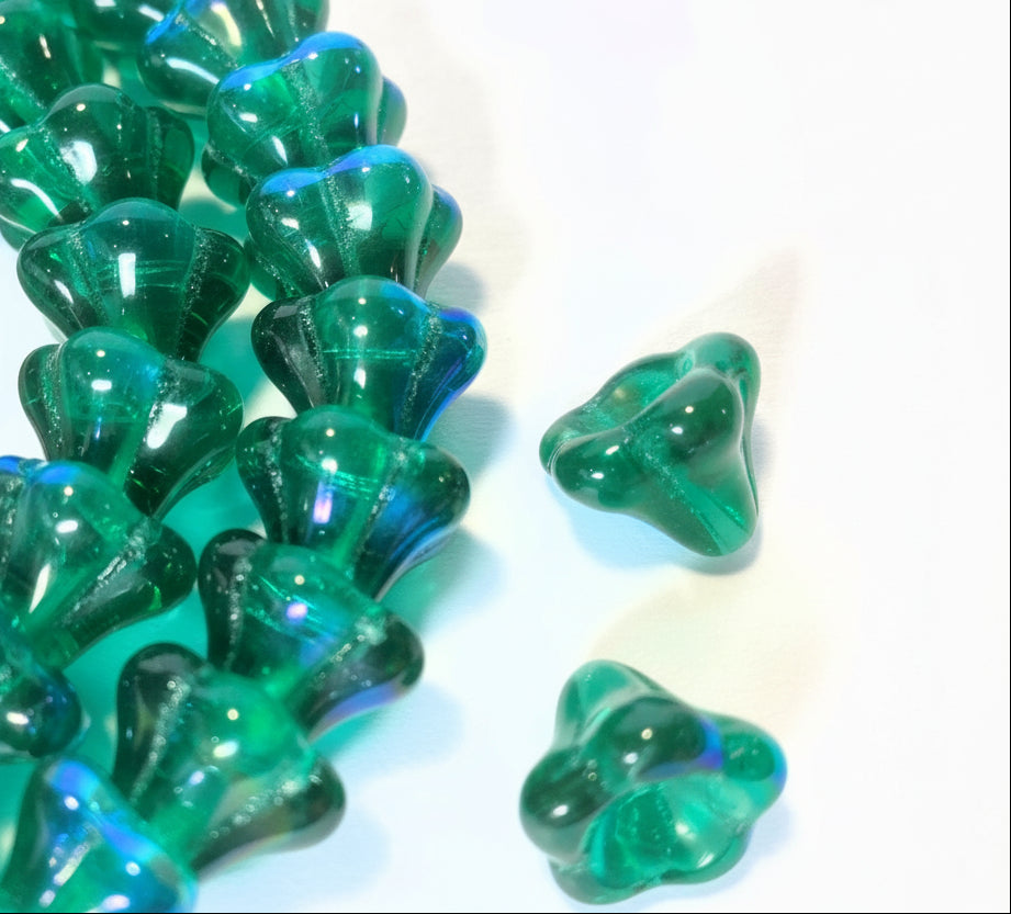 Green translucent glass beads with a scalloped, petal-like shape, shown in a close-up on a white background with a coin for scale.