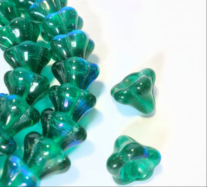 Green translucent glass beads with a scalloped, petal-like shape, shown in a close-up on a white background with a coin for scale.