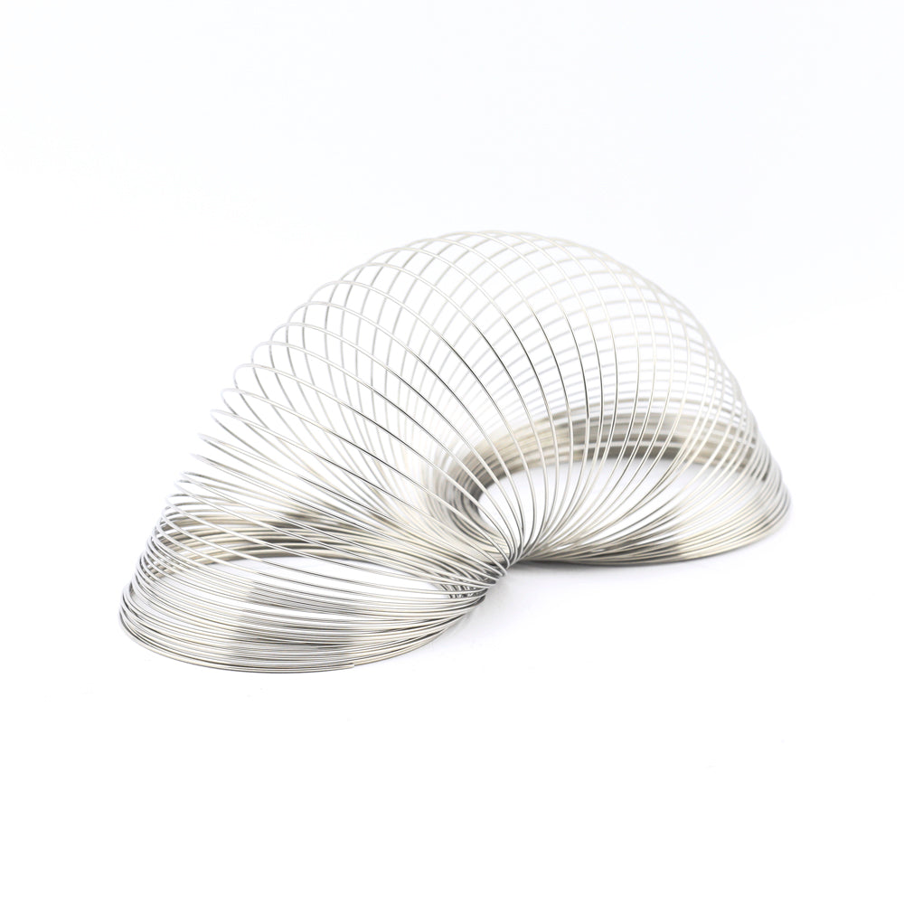A silver metal slinky toy stretched into a curved shape on a clean white background.