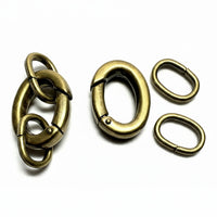 Four antique bronze metal hardware components, including two interlocking ring clamps and two oval spring rings, displayed on a plain white background.