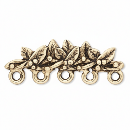 An antique gold-toned metal holly branch charm with five hanging loops, shown on a plain white background.
