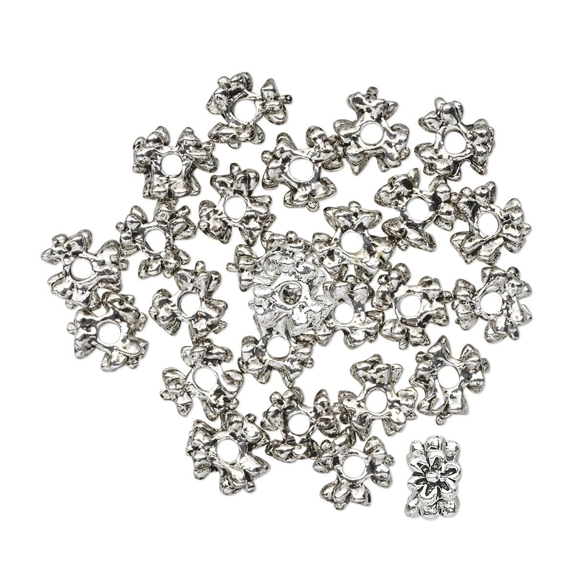 A pile of silver-toned metal flower-shaped beads with circular holes, arranged on a plain white background.
