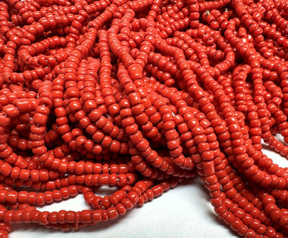 Close-up of red seed beads on a white background