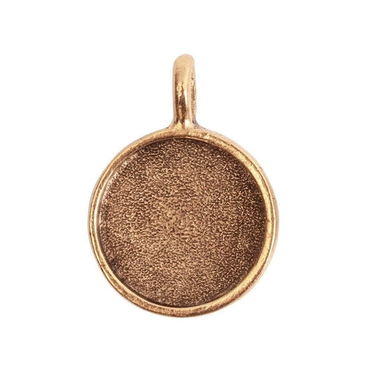 A round, empty gold-toned bezel pendant or charm with a textured center and a small top loop, shown on a plain white background.