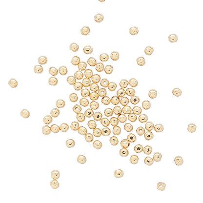 Gold beads scattered on a white background