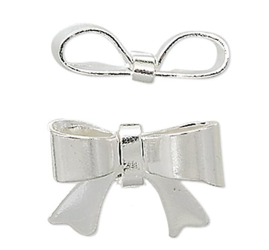 Two silver metal bow charms, one smaller and positioned above, and one larger and positioned below, shown on a plain white background.