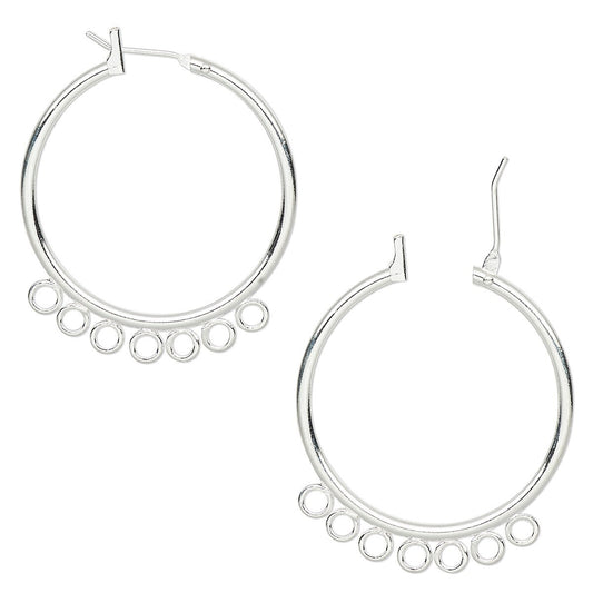 A pair of silver hoop earrings with a row of small dangling circular cutouts along the lower edge, shown on a plain white background.