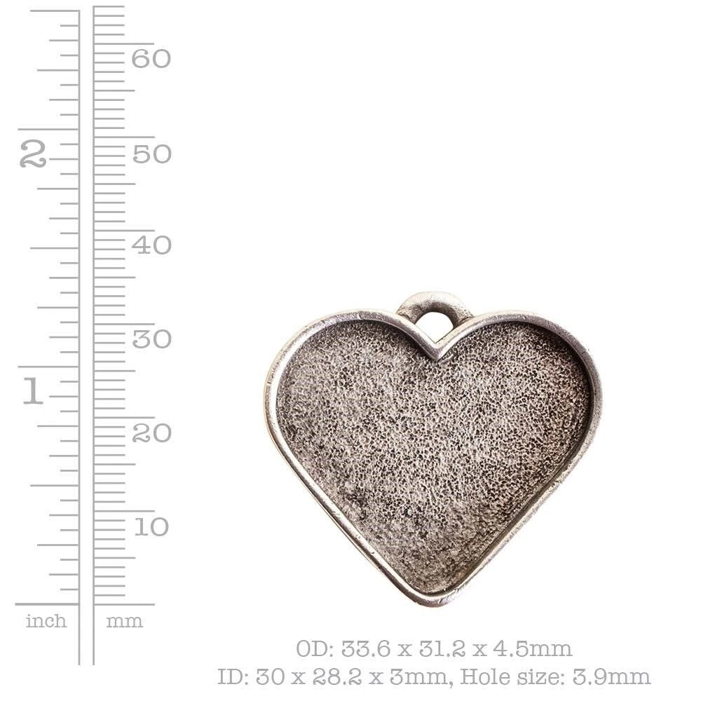 A heart-shaped silver-toned metal charm pendant with a textured center and a small top loop, shown on a white background with a height ruler on the left and size text below.