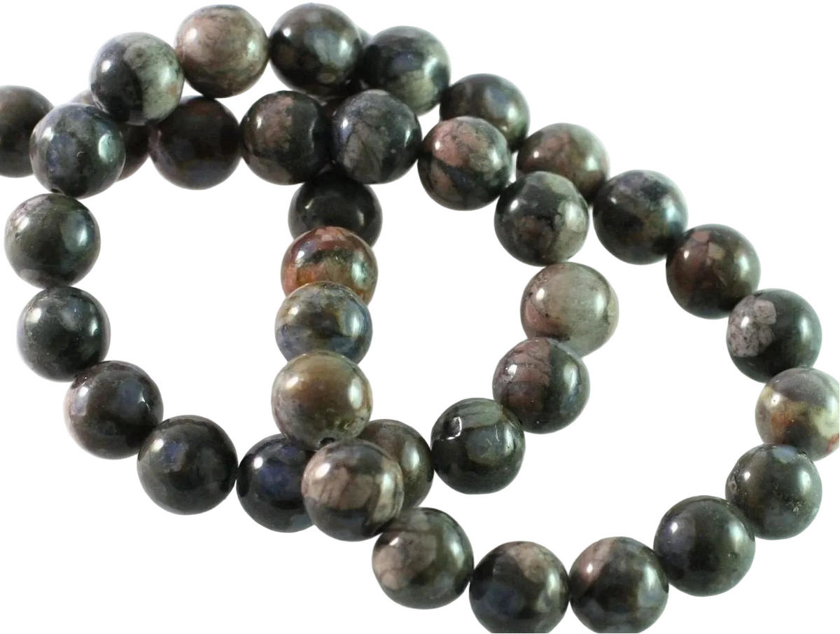 A strand of polished round gemstone beads in dark gray, black, and brown with natural marbled patterns, arranged on a plain white background.