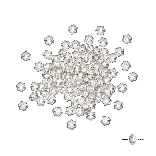 A pile of small silver star-shaped seed beads with a single bead shown separately at the bottom right on a plain white background.