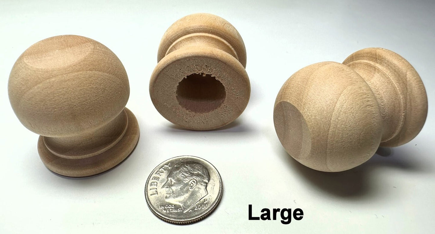 Set of large wooden knobs with a coin for scale on a white background