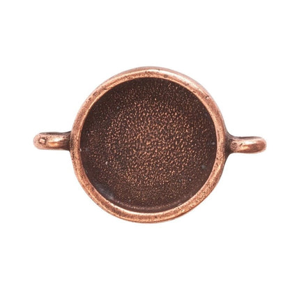 A copper-colored metal ring blank with a textured center and two small side loops, shown against a plain white background.
