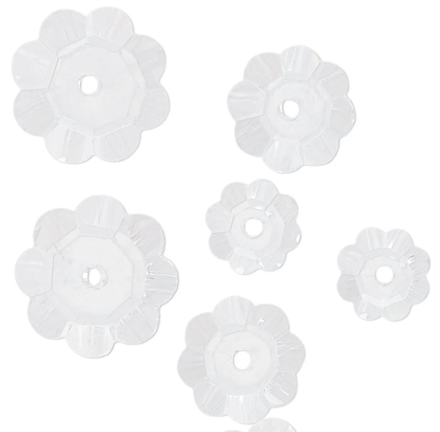 Set of six white floral-shaped beads on a white background