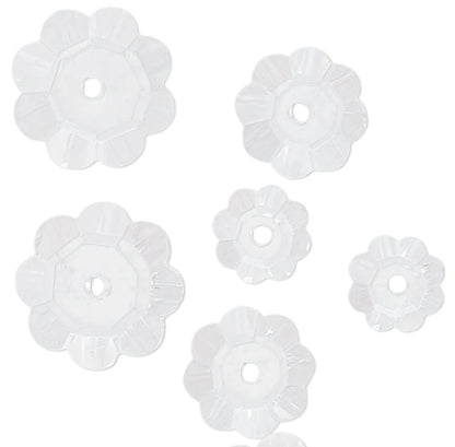 Set of six white floral-shaped beads on a white background