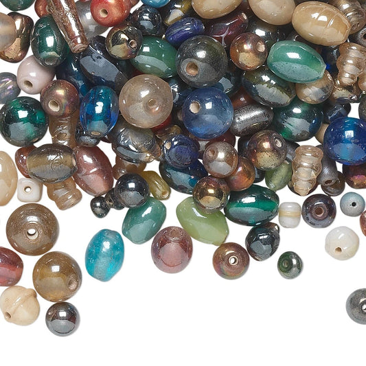 A pile of assorted polished gemstone beads in various colors and shapes, including teardrop, oval, and round styles, scattered on a plain white background.
