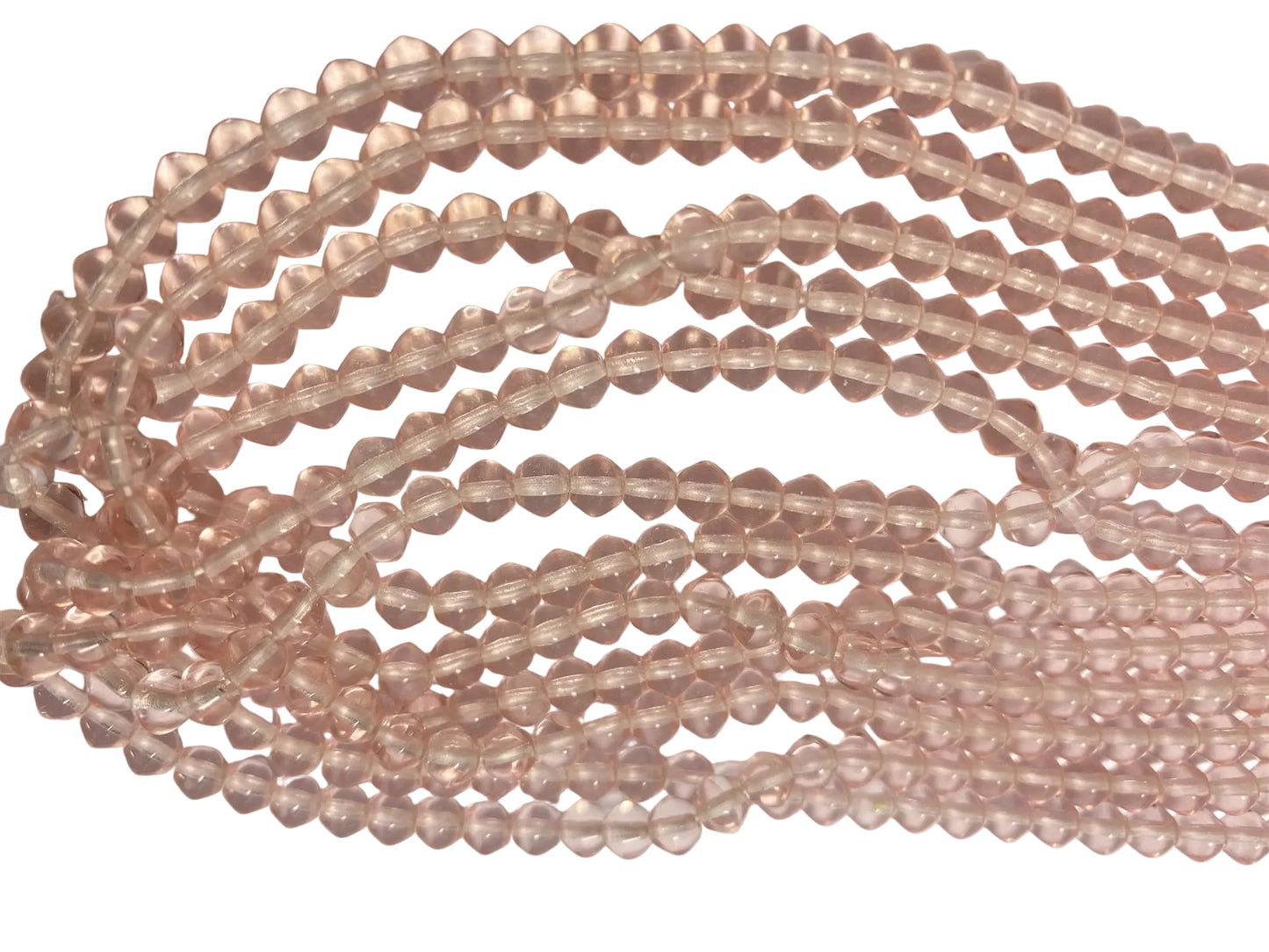 Multiple strands of faceted rose quartz beads in a light pinkish-tan hue, arranged in curved loops on a plain light background.